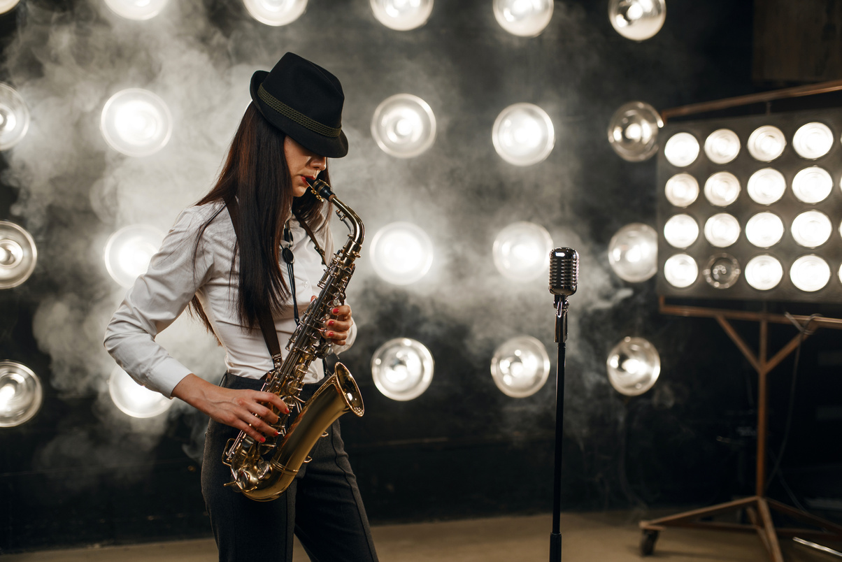 Female Jazz Musician in Hat Plays the Saxophone